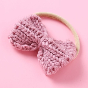 Close-up of pink knitted bow headband with soft high-elastic nylon hair band for babies