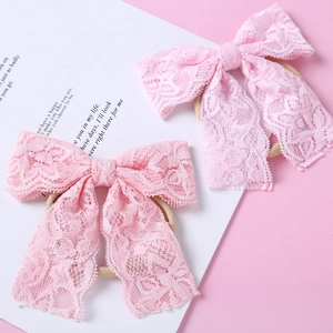 Détail de bandeaux en dentelle rose pour bébés avec texture délicate et nylon élastique