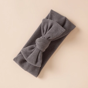 Détail de la texture d'un bandeau bébé en simili cachemire gris foncé avec nœud