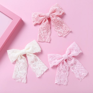 Detail von rosa und weißen Spitzen-Haarspangen mit floralem Muster und langen Bändern