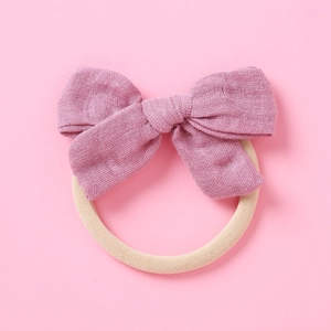 Texture détaillée d'un nœud en fibre de bambou rose poudré sur bandeau bébé