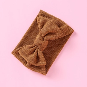 Detailansicht eines karamellfarbenen Strickstirnbands für Babys mit großer Schleife