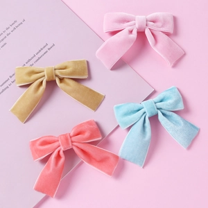 Détail de barrettes à nœuds en velours doux rose, jaune, bleu et corail pour bébés