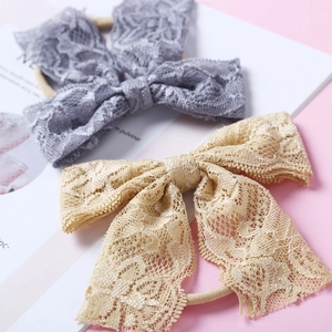 Détail de la texture en dentelle et des bandes élastiques en nylon du bandeau bébé