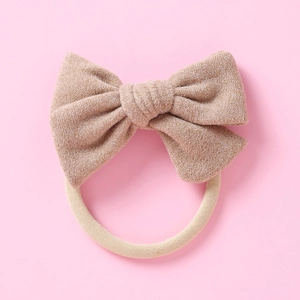 Détail d'un bandeau bébé en nylon souple avec un nœud en tweed de couleur kaki texturé