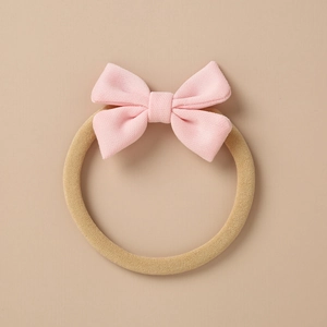 Detailed close-up of pink knitted bow with elastic nylon headband for baby hair