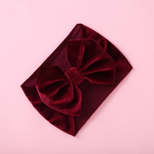 Detail of burgundy velvet baby headband showing rich texture and large bow design