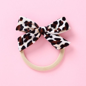 Détail d'un chouchou avec nœud en velours léopard et élastique beige de haute qualité