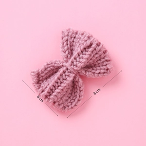 Macro detail of knit bow hair clip in dusty rose with 8cm by 6cm size dimensions