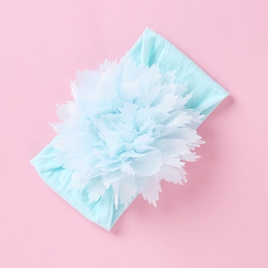 Detail eines Baby Stirnbandes mit großer hellblauer Chiffonblume auf rosa Hintergrund