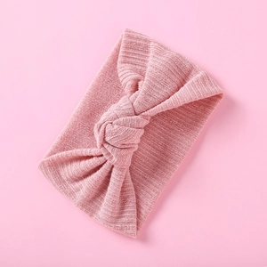 Detailansicht eines rosa Strick-Baby-Stirnbands mit Rippenstruktur und elegantem Knoten