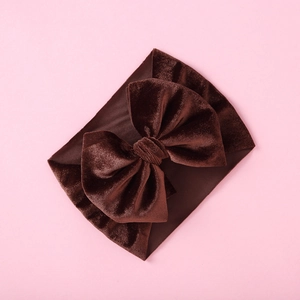 Detail of dark brown velvet bow headband showing thick texture and soft fabric shine