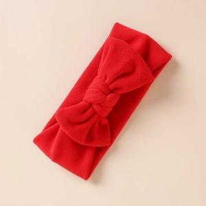 Gros plan sur un bandeau d'hiver rouge doux pour bébé avec un grand nœud décoratif