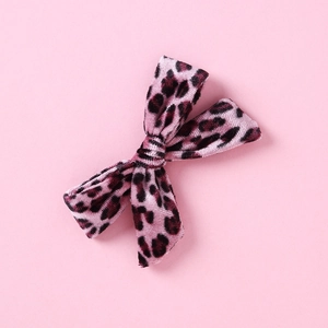 Detailed macro view of pink leopard print velvet bow hair clip with soft texture
