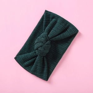 Detail eines dunkelgrünen Strick-Stirnbands für Babys mit einem geknoteten Schleifen-Design