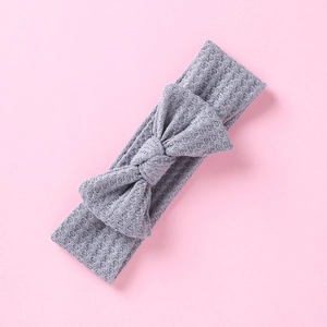Détail du bandeau bébé en maille gaufre gris clair avec un nœud décoratif mignon