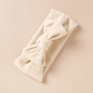 Gros plan du bandeau bébé en cachemire synthétique avec nœud de couleur blanc crème