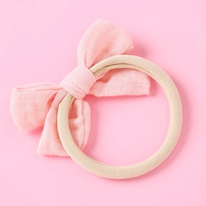 Détail du bandeau à nœud rose pour bébé avec bande en nylon élastique souple