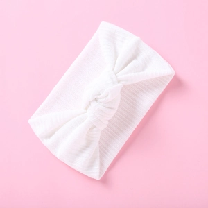 Detailansicht eines weißen gerippten Baby-Stirnbands mit dekorativem Knoten-Design