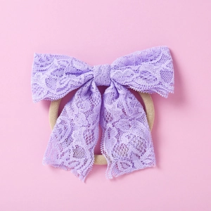 Détail d'un bandeau pour bébé avec nœud en dentelle violette et bande souple pour filles
