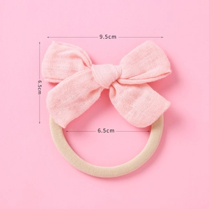 Détail du bandeau à nœud rose pour bébé avec mesures de taille de 9,5 cm et 6,5 cm