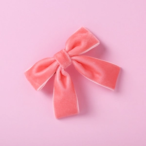 Détail du nœud papillon en velours rose corail doux pour bébés et petites filles