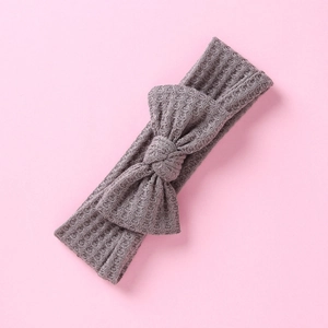 Texture détaillée du bandeau pour bébé en tricot gaufré gris avec nœud décoratif