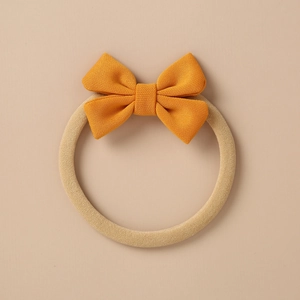 Macro view of ginger knitted bow headband with elastic beige band for infants