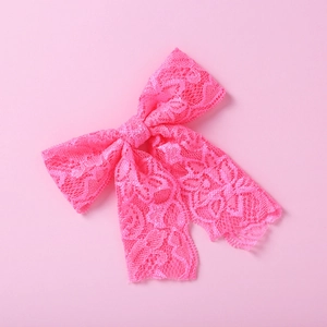 Detailansicht der pinkfarbenen Spitzen-Haarschleife mit feiner Blumenstruktur für Mädchen