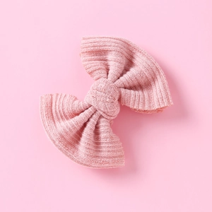 Nahaufnahme der rosa Strick-Schleifen-Haarklammer mit feiner Rippenstruktur und Knoten