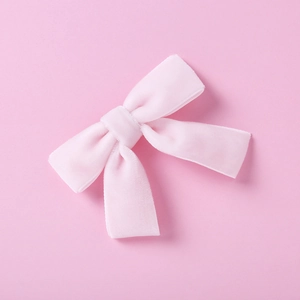Détail du nœud papillon en velours rose montrant la texture douce et la finition fine