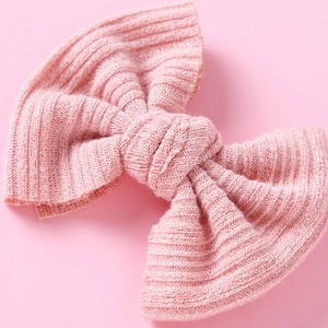 Nahaufnahme der rosa gestrickten Haarschleife mit detaillierter Rippenstruktur