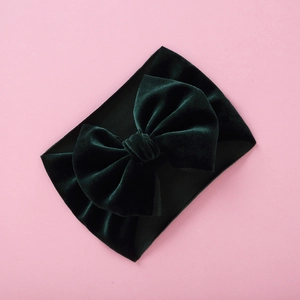 Detailed macro view of dark green velvet baby headband with a large vintage bow design
