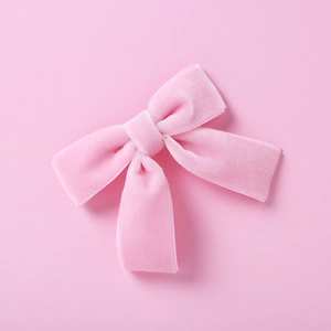 Gros plan du nœud papillon en velours rose montrant la texture douce et la couture
