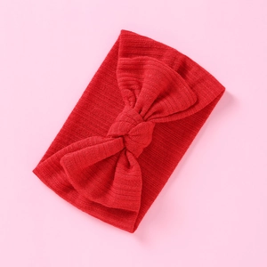 Detail der roten Rippstrick-Textur und handgefertigten Schleife am Babystirnband
