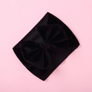 Detailed texture of black velvet baby headband with a large decorative bow
