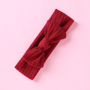 Détail d'un bandeau pour bébé en maille gaufre avec nœud de couleur rouge bordeaux