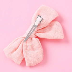 Dettaglio del fermaglio per capelli in mussola rosa con clip a coccodrillo in argento