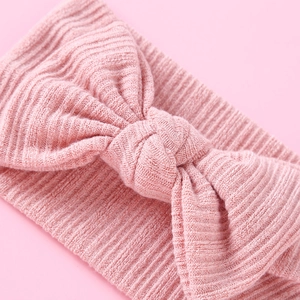 Nahaufnahme von weichem rosa Rippstrick-Stirnband mit dekorativem Schleifendetail