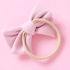 Détail d'un bandeau bébé en velours rose avec un ruban en nylon sans couture élastique