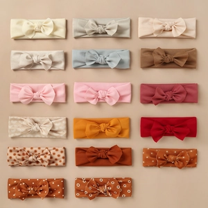 Flat lay detail showing 17 styles of soft elastic baby headbands with knot bows