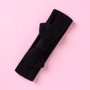 Détail du tissu gaufré noir et du grand nœud papillon sur le bandeau pour enfant