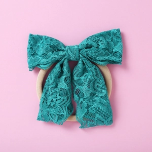 Détail du nœud en dentelle turquoise sur bandeau en nylon souple pour bébés et fillettes