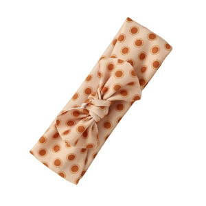 Cute peach-pink elastic bow headband for babies with orange polka dot pattern