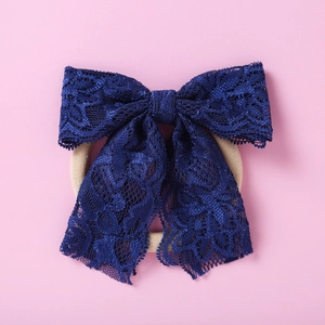 Détail du bandeau en dentelle bleu foncé avec nœud crocheté et élastique pour cheveux