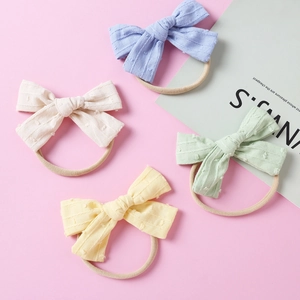 Set mit vier weichen Jacquard-Schleifen-Stirnbändern in Pastellblau, Creme, Grün und Gelb