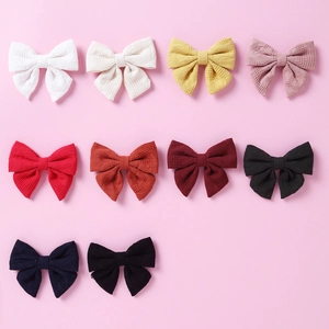 Nahaufnahme von 10 bunten Baumwoll-Haarspangen mit Schleifen und Waffelstruktur für Mädchen
