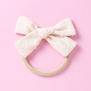 Nahaufnahme von weichem Baby Stirnband mit beige Jacquard-Schleife und Nylon-Gummiband