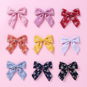 Lot de neuf nœuds papillon en coton coloré avec broderies florales blanches pour filles