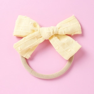 Nahaufnahme gelbes Baby-Stirnband mit gepunkteter Textur und elastischem Nylonband-Detail